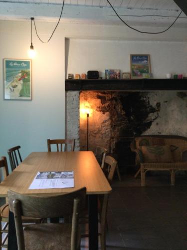 une salle à manger avec une table et une cheminée dans l'établissement Le Tiot Décalé - LE MONT DE LA LOUVE, à Bazinghen