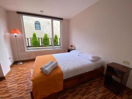 a bedroom with a bed and a large window at Hotel Shannon 360 in Baños