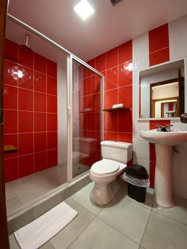a bathroom with a toilet and a shower and a sink at Hotel Shannon 360 in Baños