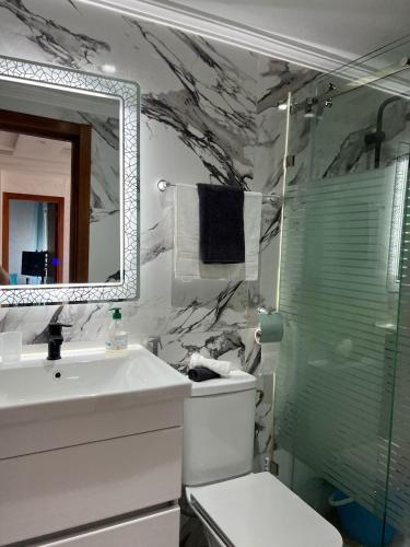 a bathroom with a toilet and a sink and a shower at Beach Condo - 2 Mins from Ocean in Tangier