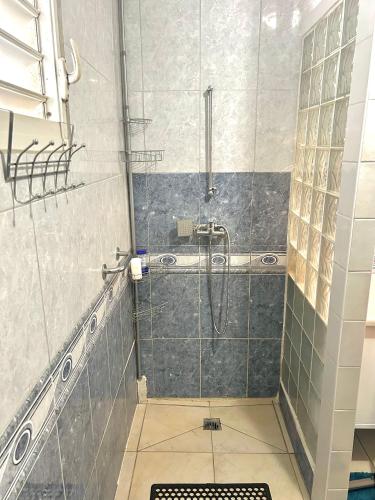 a bathroom with a shower with a glass door at Magnifique bas de villa idéalement situé in Les Abymes