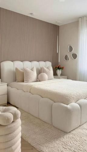 a large white bed with a large white couch at Hostel Paradiso in Chaguanas
