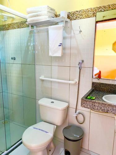 a bathroom with a toilet and a shower and a sink at Pousada Sonho de Mar in Luis Correia