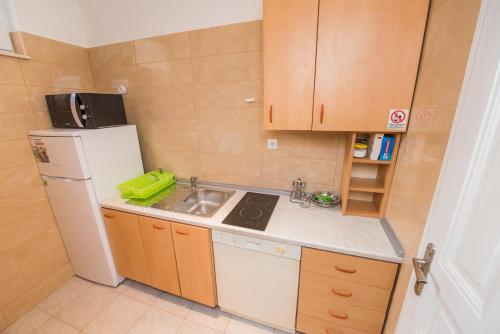 a small kitchen with a sink and a refrigerator at Apartment Vetom in Split