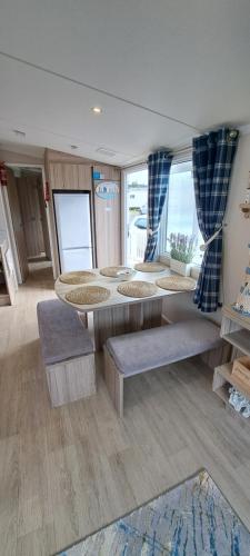 a room with four tables and benches in a room at Sea view holiday home with accessible ramp and WiFi in Port Seton