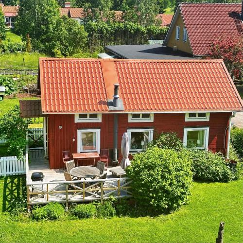 a small house with an orange roof and a deck at Visthuset, historical cottage at Långnäs Manor in Långnäs