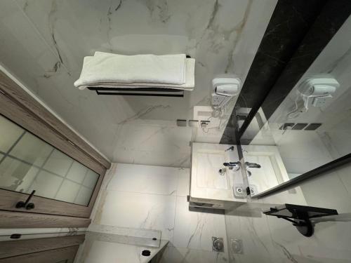 a white bathroom with a sink and a towel at SIXTY THREE HOTEL SUiTES in Riyadh