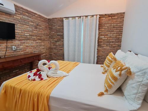 a bedroom with two swans towels on a bed at Chalés Refúgio Fortim in Fortim