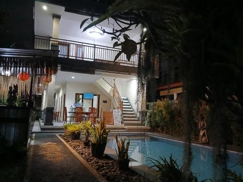 a house with a swimming pool and a balcony at Obama House Ubud in Ubud