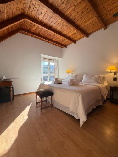 a bedroom with a large bed and a window at Hosteria Las Walkirias in San Martín de los Andes