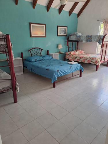 a bedroom with two beds and a blue wall at Casa en Tocaima Cundinamarca in Tocaima