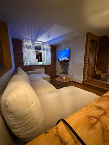 a bedroom with two beds and a flat screen tv at Hosteria Las Walkirias in San Martín de los Andes