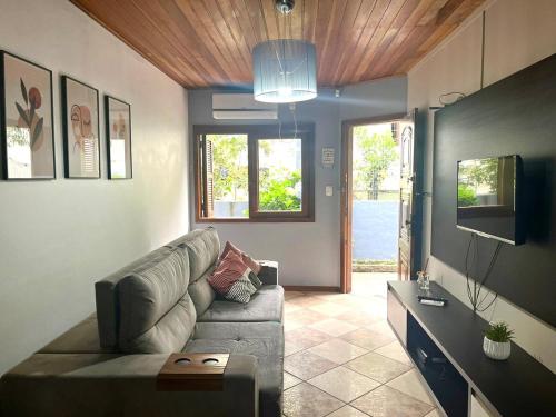 a living room with a couch and a tv at Sobrado Vinhedos Serra Gaúcha - Caxias do Sul in Caxias do Sul
