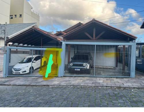 a building with a gate with two cars in it at Sobrado Vinhedos Serra Gaúcha - Caxias do Sul in Caxias do Sul