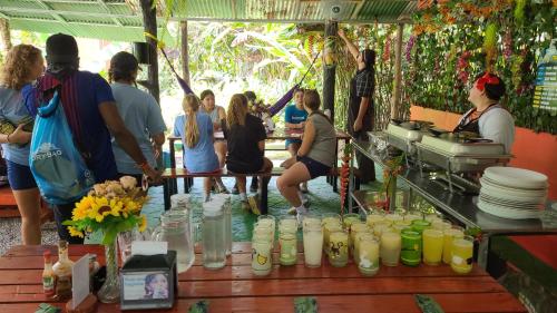 a group of people standing around a table with drinks at Chalets Silencio del Bosque in Fortuna