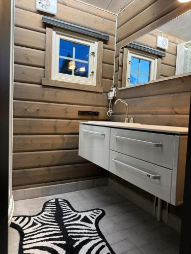 a bathroom with a sink and a zebra rug at Fjellhytte med jacuzzi, badstue mulighet in Bjorli
