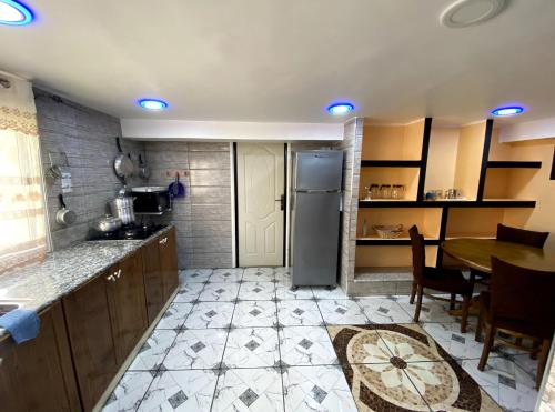 a kitchen with a table and a refrigerator at Adem s1 in 'Aïn el Turk