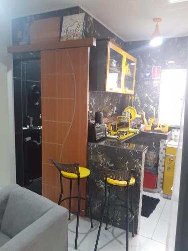 a kitchen with a counter and two stools in it at FLAT -Apartamento na Pedreira Belém in Belém