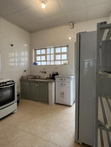 a kitchen with a refrigerator and a sink in it at Casa grande e arejada ao lado da praia! in Itanhaém