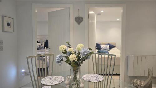 a glass table with a vase of flowers on it at Charlies Cottage in Inverness