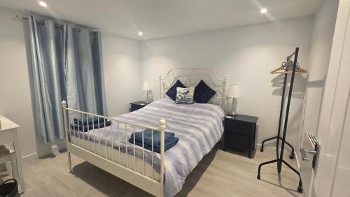 a bedroom with a white bed with a metal frame at Charlies Cottage in Inverness