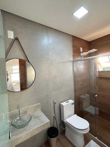 a bathroom with a toilet and a sink and a mirror at Pousada Recanto das Estrelas in São Thomé das Letras