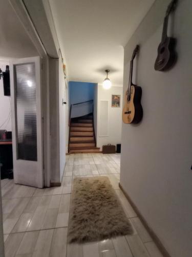 a hallway with guitars hanging on the wall and a rug at Wind Guest House in Valparaíso