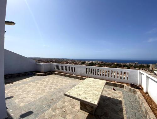 een patio met een tafel bovenop een gebouw bij Adem s6 in 'Aïn el Turk