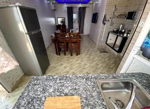 een keuken met een wastafel en een tafel en stoelen bij Adem s6 in 'Aïn el Turk