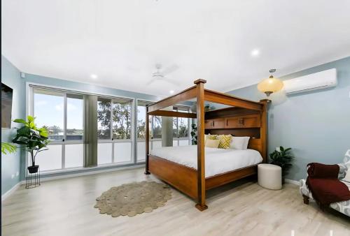 Un dormitorio con cama con dosel y grandes ventanales. en Wine Stop Quarters Pool, Tour, Pickup Wineries, en Nulkaba