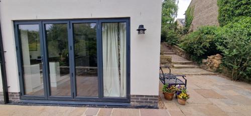 eine Glasschiebetür auf einem Haus mit einer Bank in der Unterkunft Vintage vibe with modern conveniences - Sheffield & Peak District! in Stannington