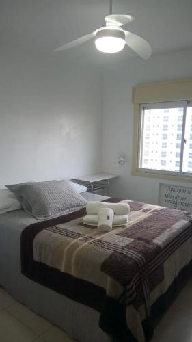 a bedroom with a bed with two towels on it at Apartamento quadra mar, 1 dos quartos com ar-condicionado , Barra Sul in Balneário Camboriú