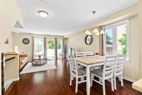 a dining room and living room with a table and chairs at Cozy modern condo 15 mins from DT with Free Parking in Ottawa