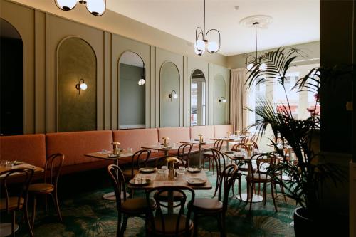 a restaurant with tables and chairs in a room at Ramsgate Hotel by Nightcap Social in Adelaide