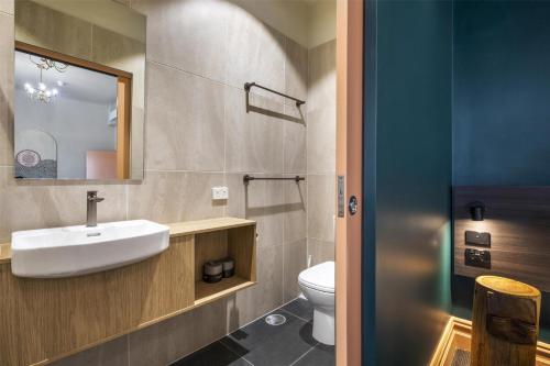 a bathroom with a sink and a toilet at Ramsgate Hotel by Nightcap Social in Adelaide