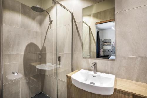 a bathroom with a sink and a shower and a mirror at Ramsgate Hotel by Nightcap Social in Adelaide