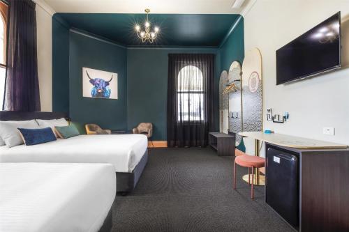 a hotel room with two beds and a tv at Ramsgate Hotel by Nightcap Social in Adelaide