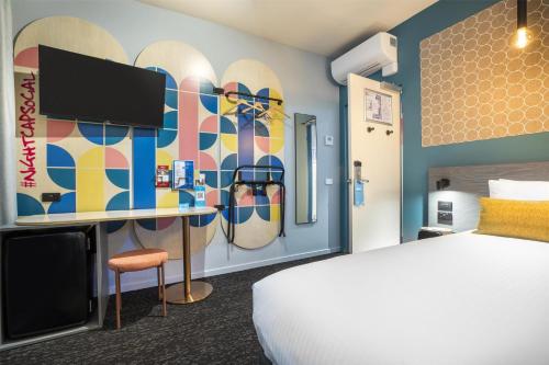 a hotel room with a bed and a wall with a mural at Royal Hotel by Nightcap Social in Melbourne