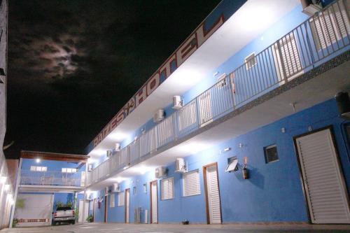 a blue and white building with lights on it at Raízes Hotel in Cajobi