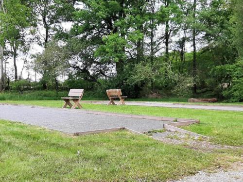 a park bench sitting in the grass next to a path at Luxury Villa in France with Private Pool in Les Forges