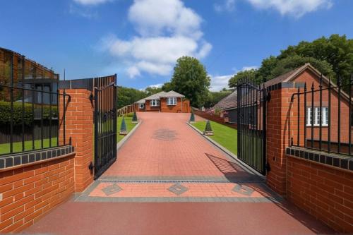 ダドリーにあるStylish Detached Bungalowの2軒の家の間にあるレンガの歩道とレンガの柵