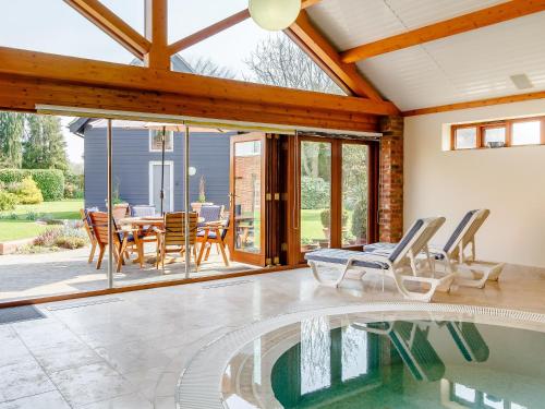 a house with a swimming pool and a dining room at Granary Barn - Ukc5405 in Banham