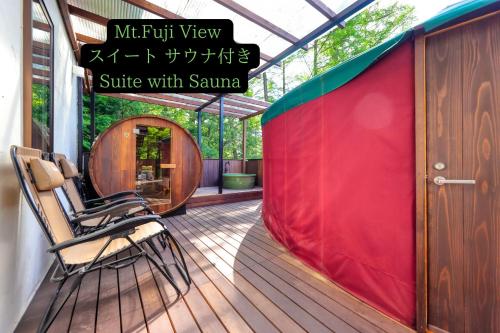 a deck with chairs and a red tent at Altitude -アルティチュード-939 富士山の麓グランピング in Fujiyoshida