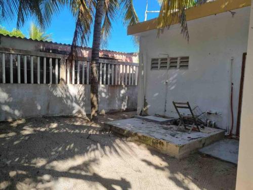 a chair sitting outside of a white building at Chelem Puerto Furnished House in Chelem