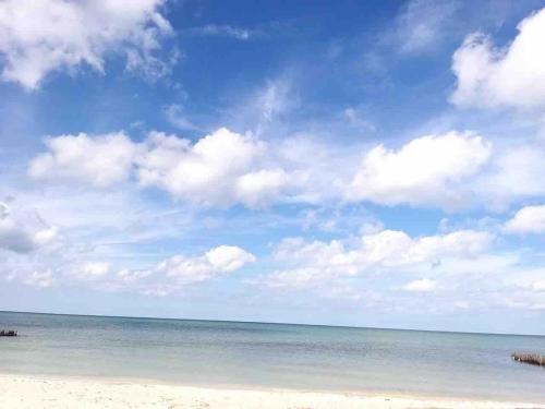 a beach with a cloudy sky and the ocean at Chelem Puerto Furnished House in Chelem