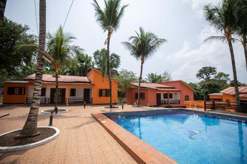 a resort with a swimming pool and palm trees at Refúgio Da Ilha in Rio do Ouro