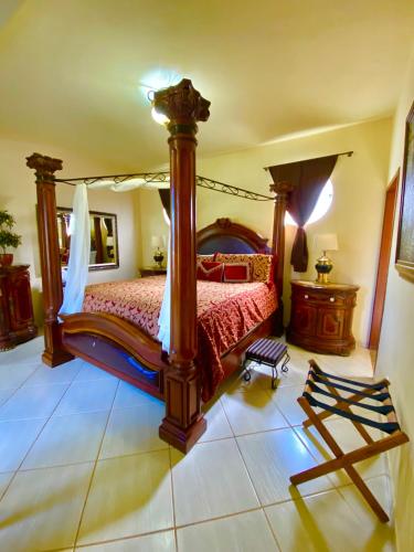 a bedroom with a canopy bed and a tiled floor at Pousada Altitude 1200 in Fazendinha