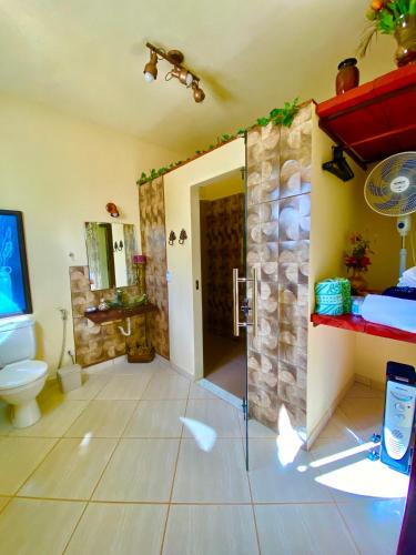 a bathroom with a shower with a toilet and a sink at Pousada Altitude 1200 in Fazendinha