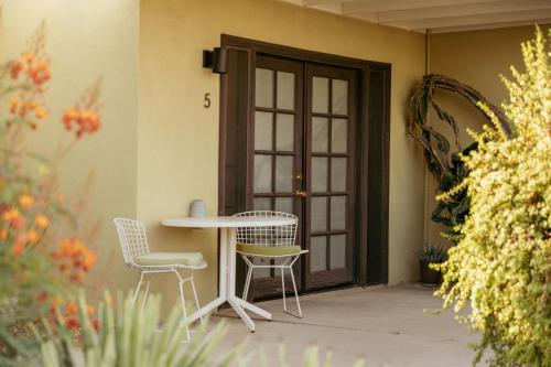 a patio with a table and chairs and a door at Hope Springs Resort in Desert Hot Springs