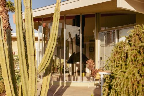 a house with glass doors and trees in front of it at Hope Springs Resort in Desert Hot Springs
